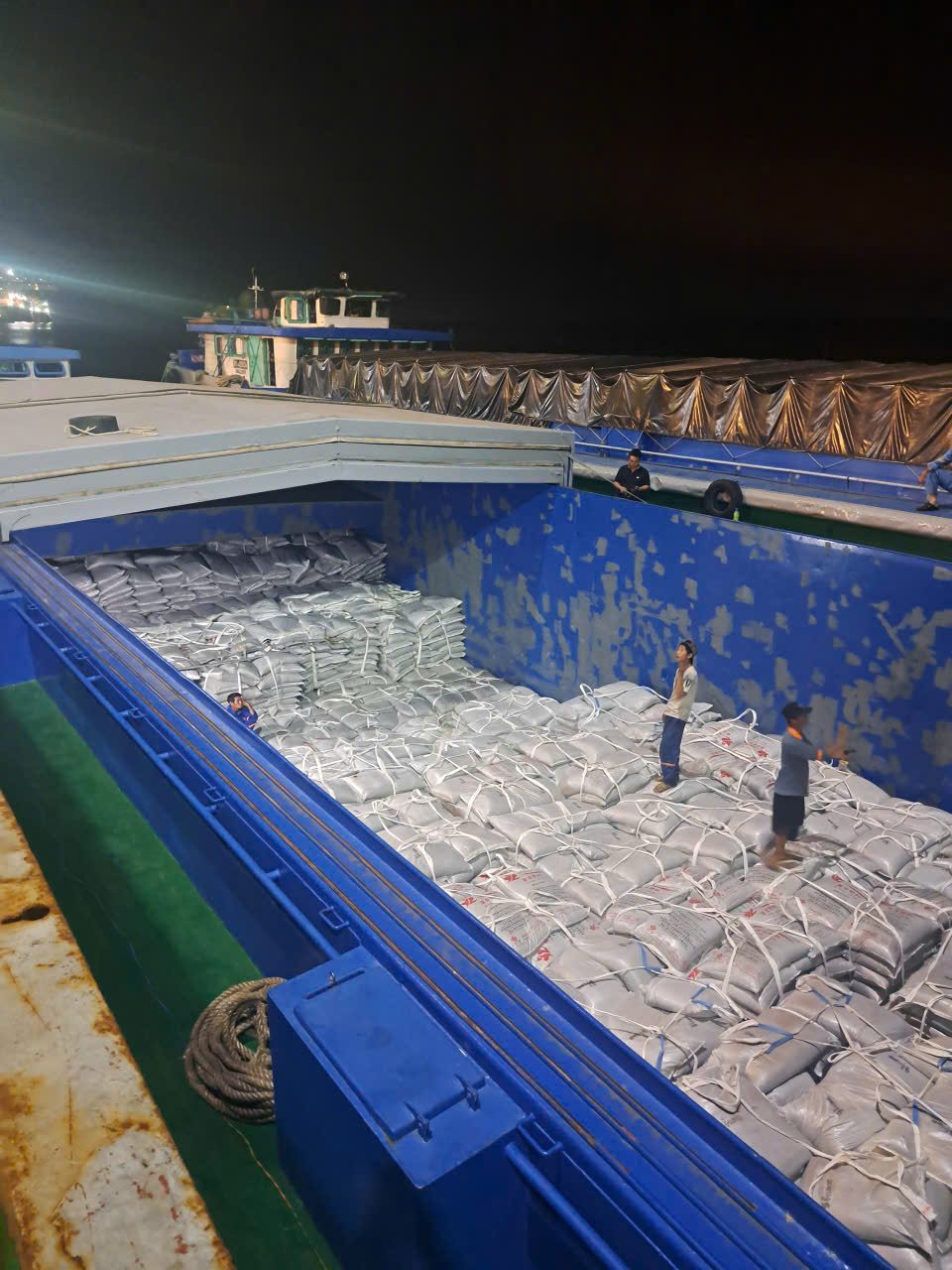 Loading fertilizer onto a VIKATRANS barge at night